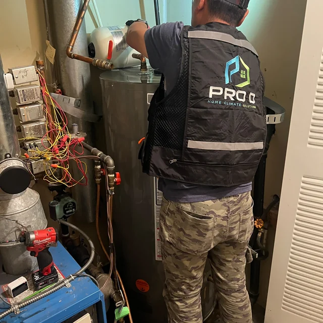 Technician working on the tank water heater in the Langley rental home project